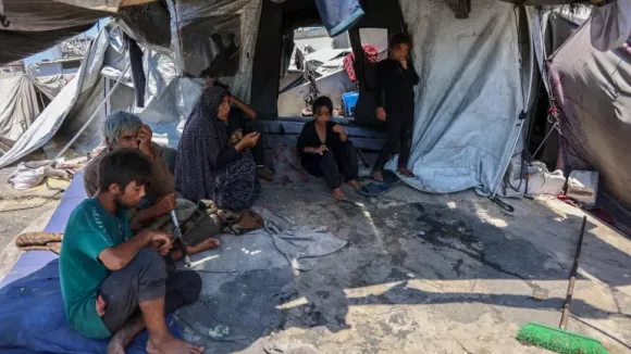 Members of a Palestinian family sit outside their tent in the Daraj neighbourhood in Gaza City [Omar Al-Qattaa/AFP]