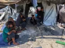 Members of a Palestinian family sit outside their tent in the Daraj neighbourhood in Gaza City [Omar Al-Qattaa/AFP]